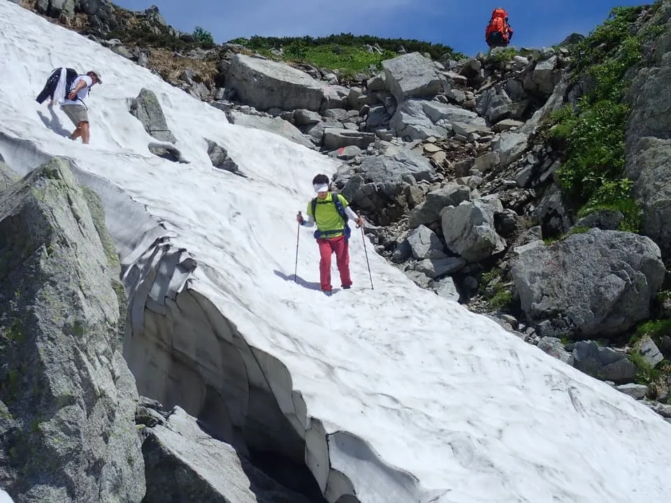 鬼岳の雪渓を慎重に下る有田さん